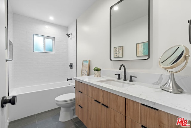 full bathroom featuring tile patterned floors, vanity, toilet, and tiled shower / bath combo