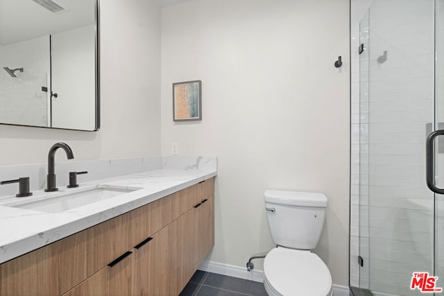 bathroom with tile patterned flooring, vanity, toilet, and walk in shower