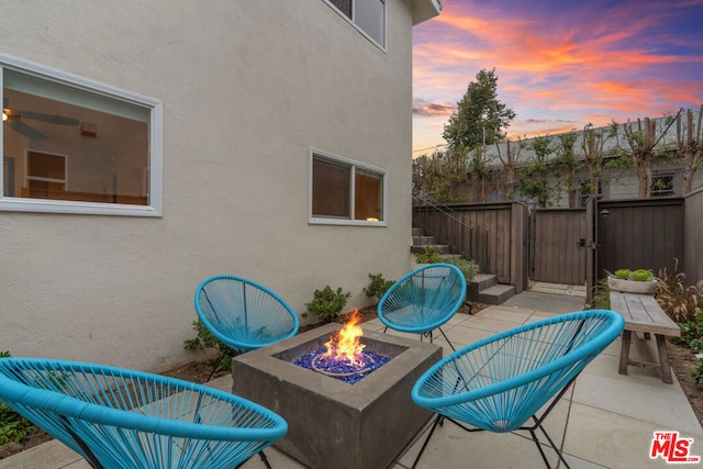 patio terrace at dusk featuring an outdoor fire pit