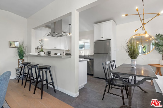 kitchen featuring white cabinets, a wealth of natural light, kitchen peninsula, and appliances with stainless steel finishes