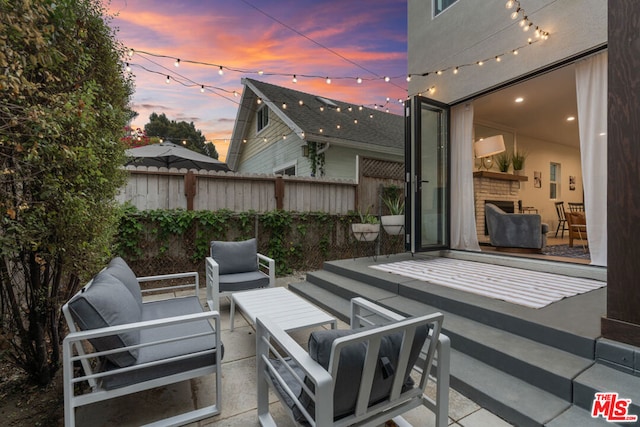 patio terrace at dusk featuring an outdoor hangout area