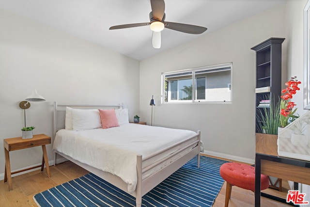 bedroom featuring ceiling fan, hardwood / wood-style floors, and lofted ceiling