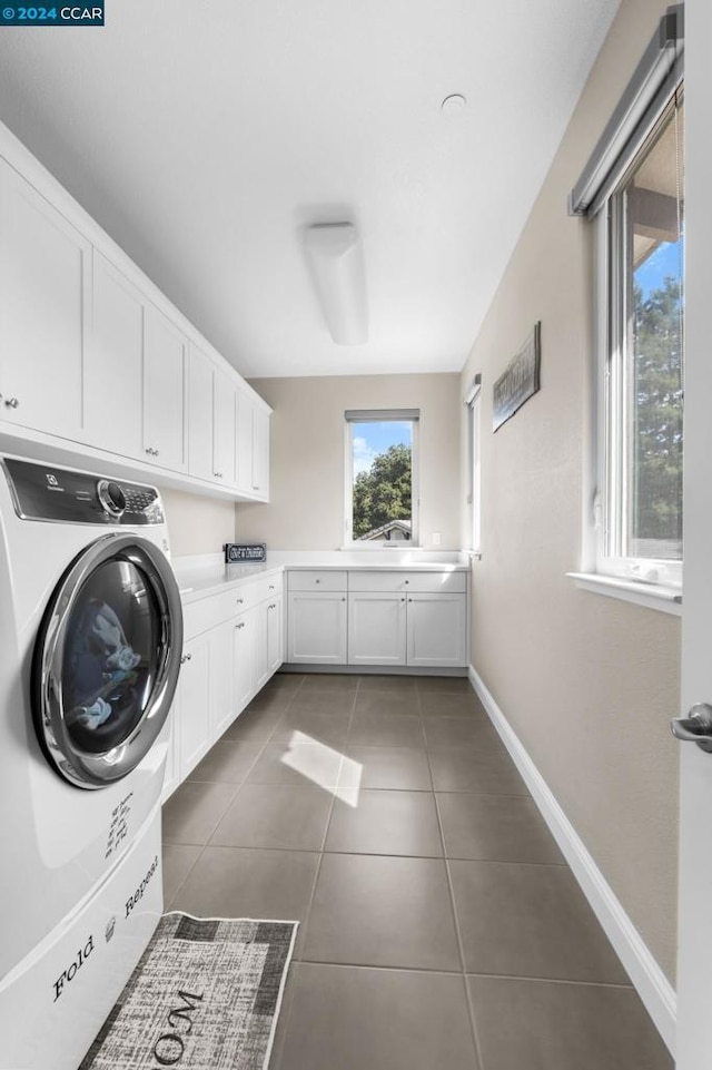 washroom with cabinets, washer / dryer, and dark tile patterned floors