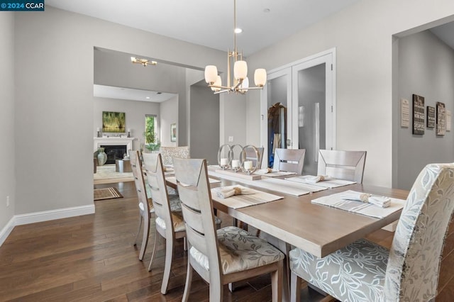 dining area with dark hardwood / wood-style floors and an inviting chandelier