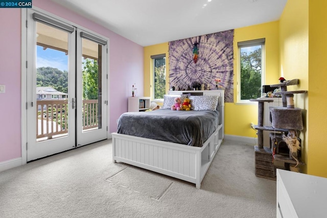 bedroom with access to exterior and light colored carpet