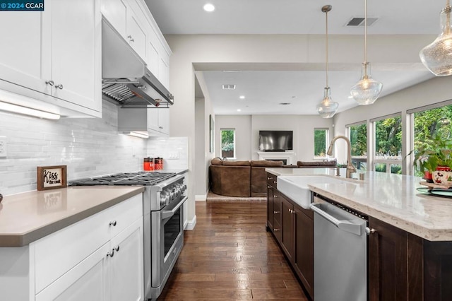 kitchen with sink, dark hardwood / wood-style flooring, pendant lighting, white cabinets, and appliances with stainless steel finishes