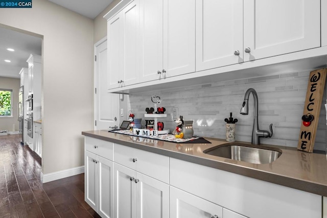 kitchen featuring tasteful backsplash, white cabinetry, sink, and dark hardwood / wood-style floors