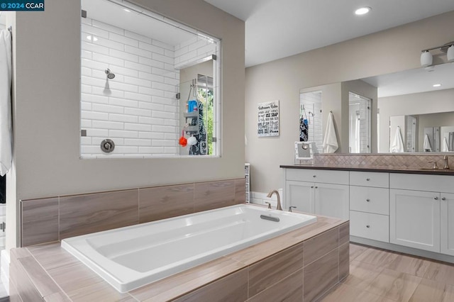 bathroom with vanity and independent shower and bath