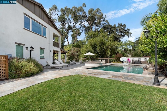 view of pool with a lawn and a patio area