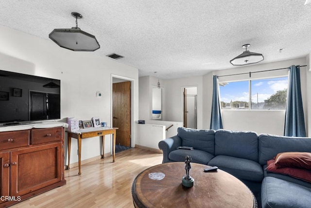 living room with light hardwood / wood-style floors and a textured ceiling