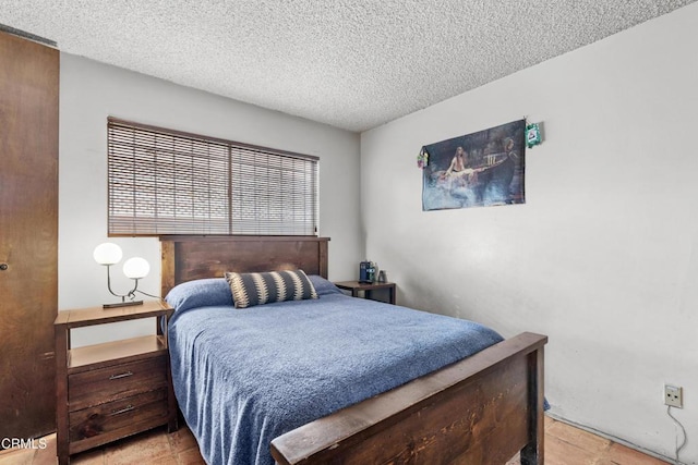 bedroom featuring a textured ceiling and light tile patterned flooring