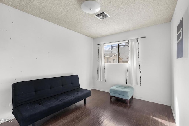 sitting room with a textured ceiling and dark hardwood / wood-style flooring