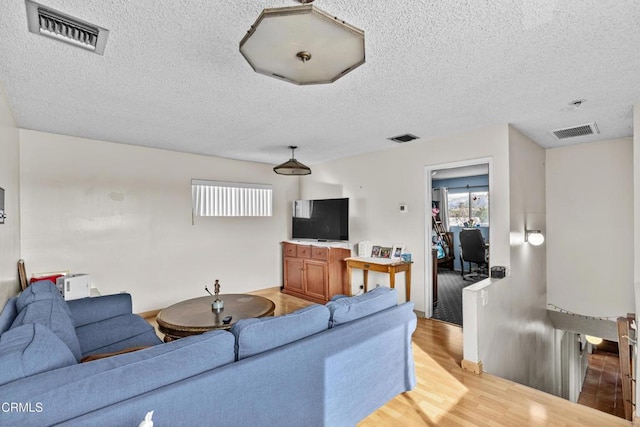 living room featuring light hardwood / wood-style floors and a textured ceiling