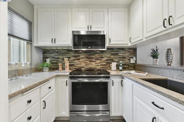 kitchen featuring light stone countertops, white cabinetry, and stainless steel appliances