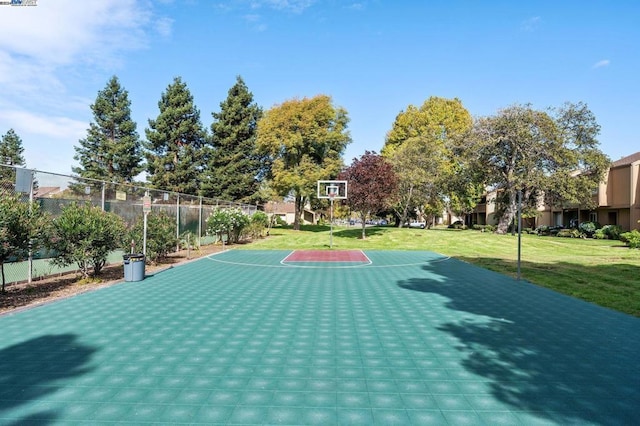 view of basketball court with a yard