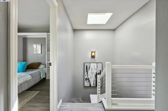 stairway with a skylight and wood-type flooring