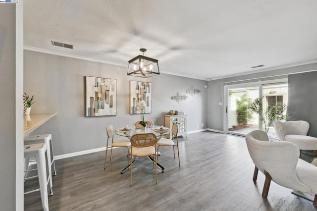 dining space featuring crown molding, dark hardwood / wood-style floors, and a notable chandelier