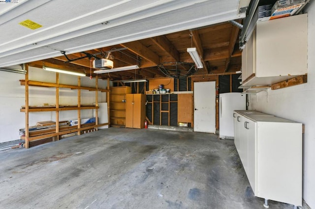 garage with white refrigerator and a garage door opener