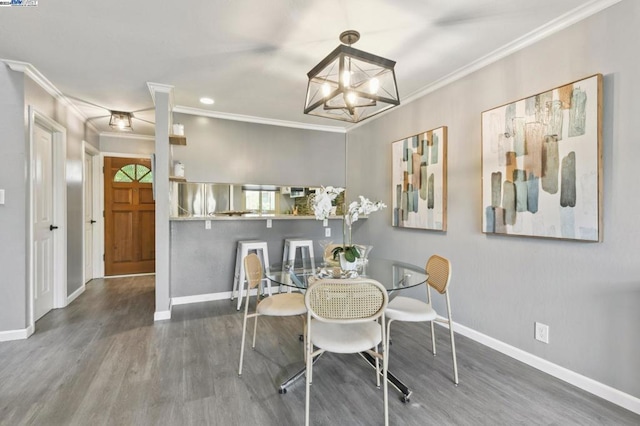 dining room with crown molding, hardwood / wood-style floors, and a chandelier