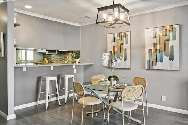 dining space featuring dark hardwood / wood-style floors, ornamental molding, and a chandelier