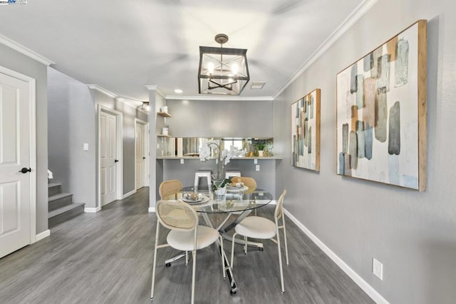 dining room featuring dark hardwood / wood-style floors, ornamental molding, and a chandelier