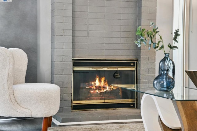 details with hardwood / wood-style floors and a brick fireplace