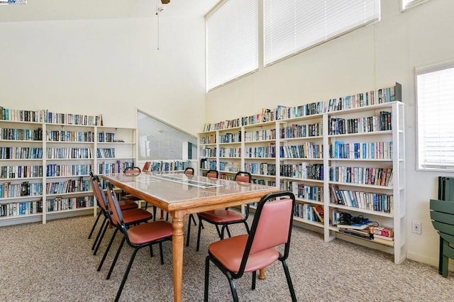 carpeted dining space featuring a high ceiling