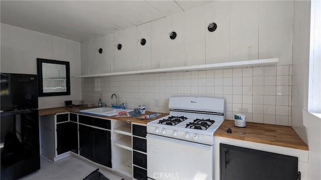 kitchen with wood counters, backsplash, white cabinets, sink, and white range with gas stovetop