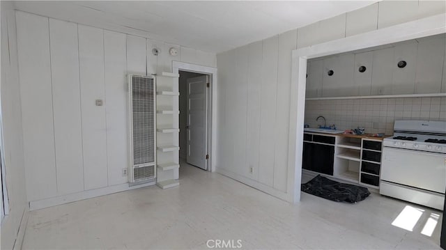 kitchen with tasteful backsplash, sink, and gas range gas stove