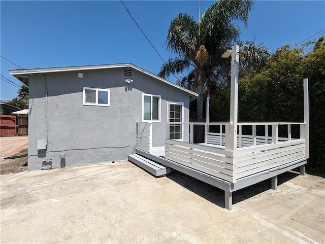 rear view of house featuring a wooden deck