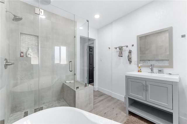 bathroom with vanity, plus walk in shower, and hardwood / wood-style floors