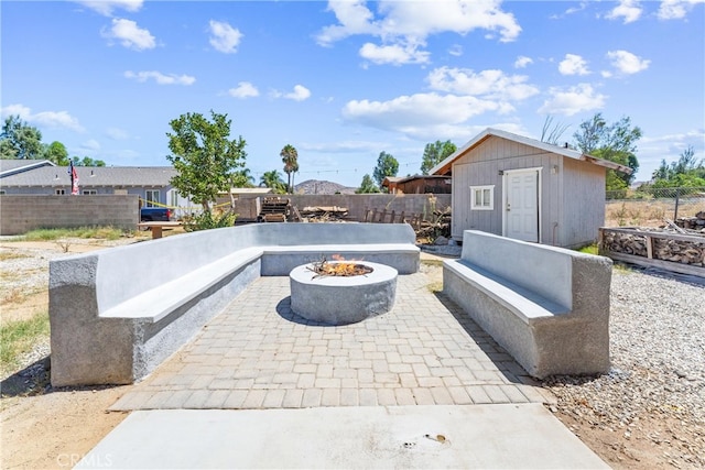 view of patio featuring a shed and an outdoor fire pit