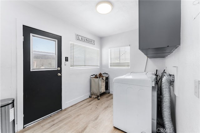 washroom with washer / clothes dryer, light hardwood / wood-style flooring, and cabinets