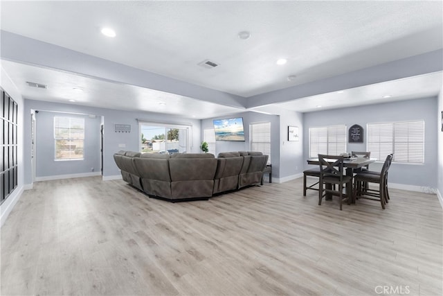 living room with a textured ceiling and light wood-type flooring