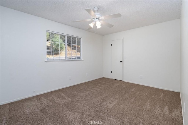 empty room featuring ceiling fan, carpet floors, and a textured ceiling