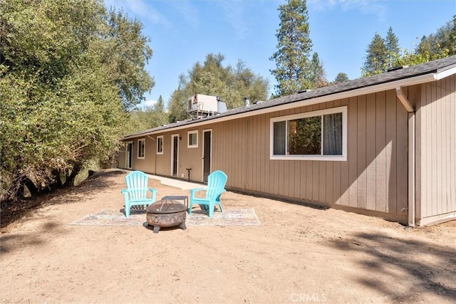 back of house featuring central air condition unit and a fire pit