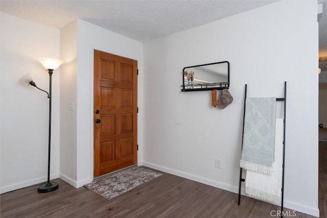 foyer entrance featuring dark hardwood / wood-style flooring and a textured ceiling