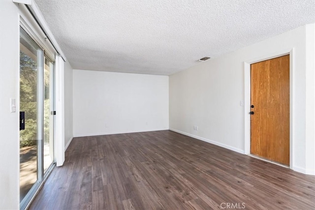 unfurnished room with a textured ceiling and dark wood-type flooring