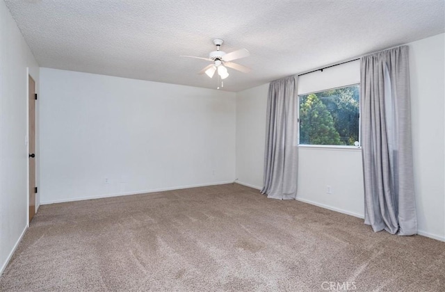 carpeted spare room featuring ceiling fan and a textured ceiling