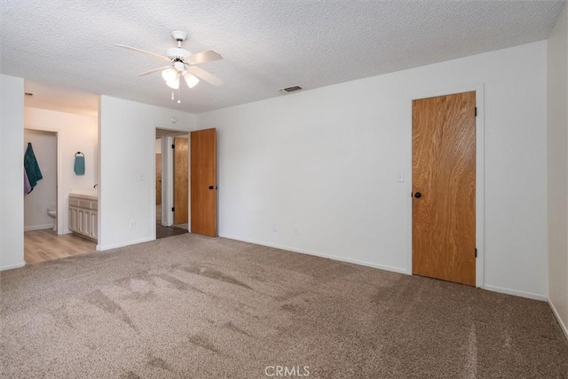 carpeted spare room with a textured ceiling and ceiling fan