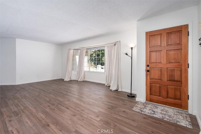 foyer with dark hardwood / wood-style flooring and a textured ceiling