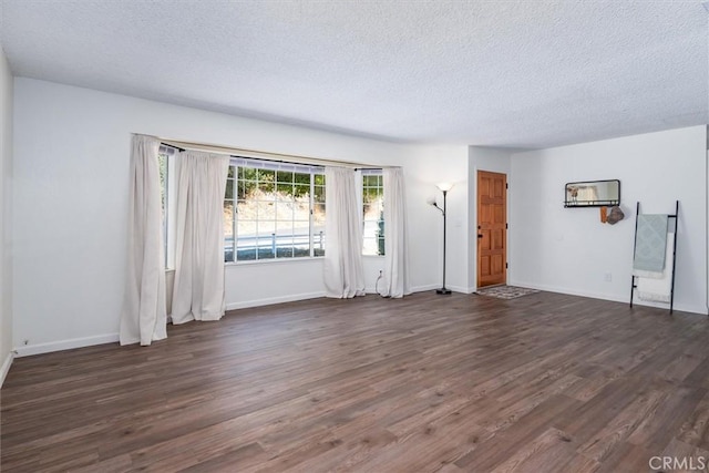 unfurnished living room featuring a textured ceiling and dark hardwood / wood-style floors