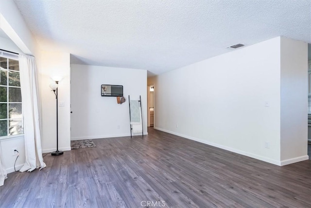 unfurnished room featuring dark hardwood / wood-style flooring and a textured ceiling