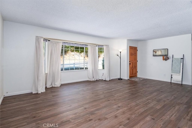 unfurnished living room with dark hardwood / wood-style flooring and a textured ceiling