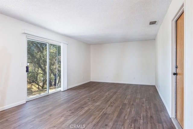 unfurnished room with dark hardwood / wood-style flooring and a textured ceiling