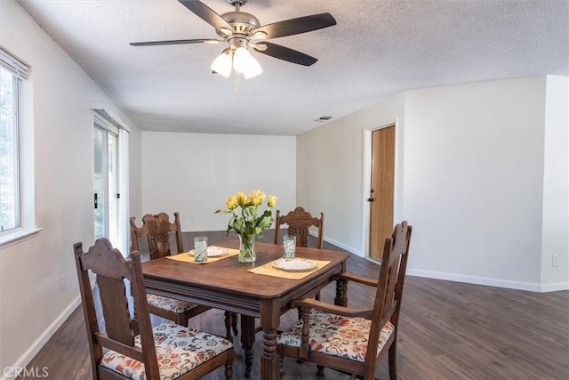 dining space featuring plenty of natural light, dark hardwood / wood-style floors, and a textured ceiling