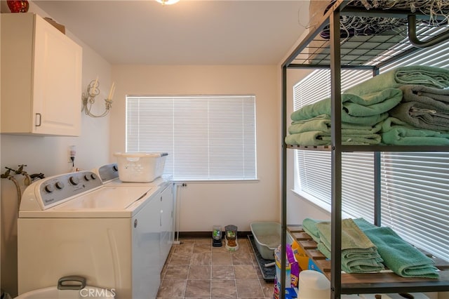 laundry room featuring separate washer and dryer and cabinets