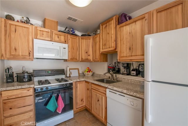 kitchen featuring light tile patterned flooring, white appliances, light stone countertops, light brown cabinetry, and sink