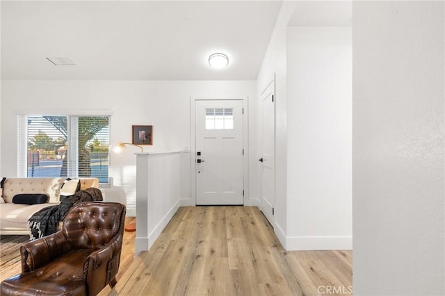 entryway with light wood finished floors and baseboards