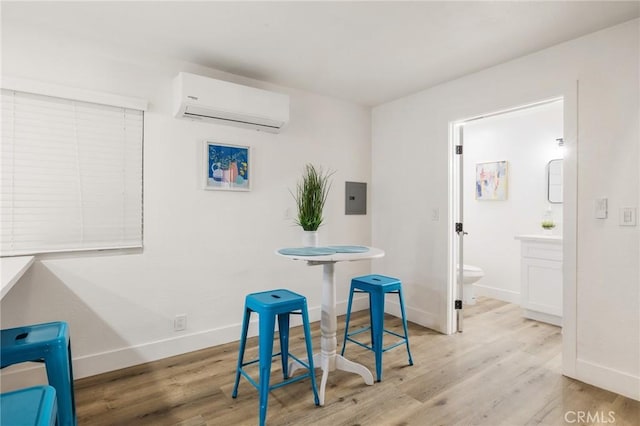 dining area featuring electric panel, baseboards, wood finished floors, and a wall mounted air conditioner